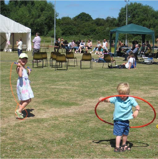 Outdoor children playing with hula hoops in a field