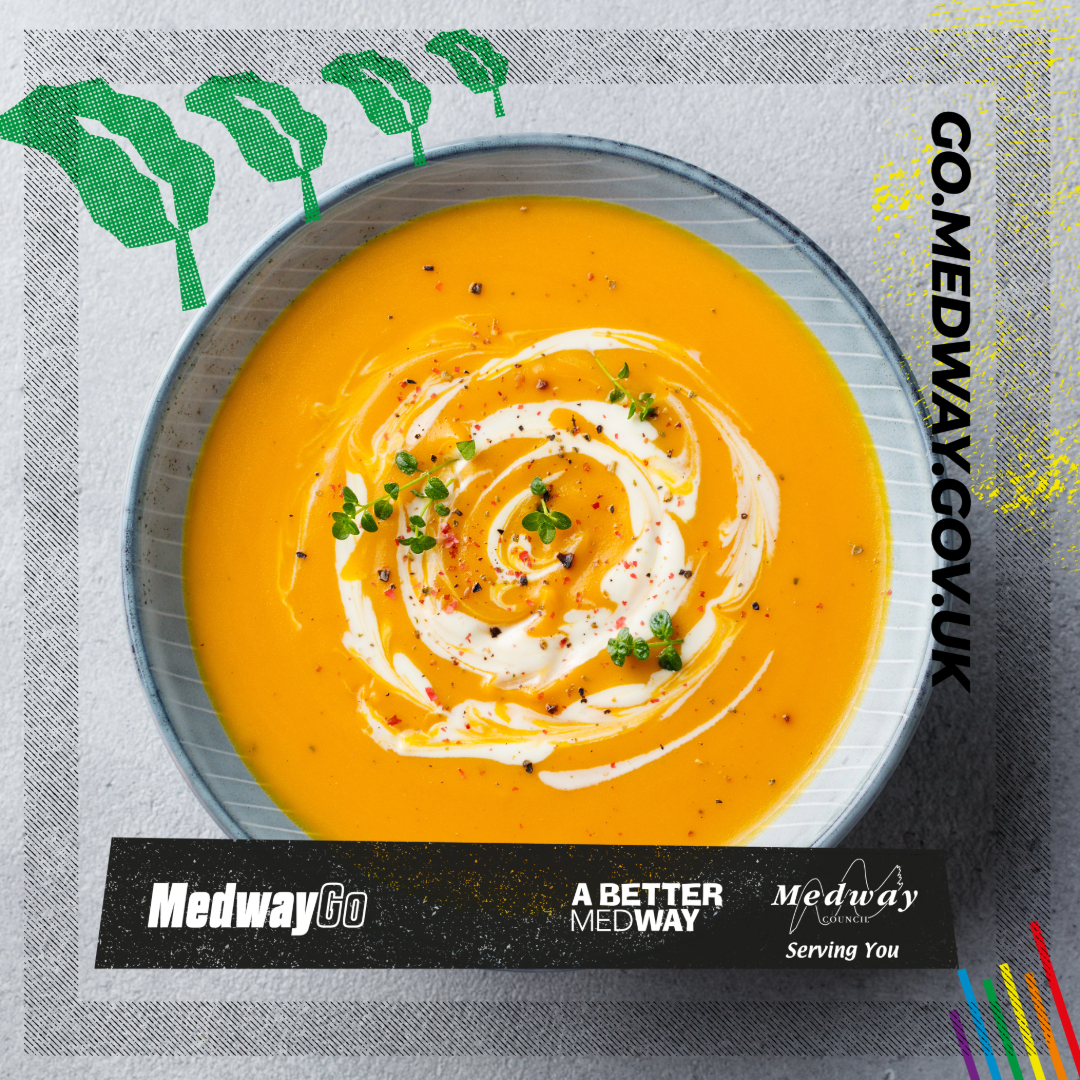 A bowl of sweet potato and butternut squash soup with swirl of cream and garnish. 