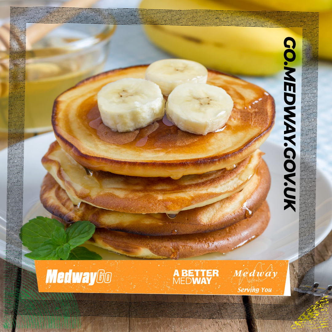 A stack of banana pancakes, topped with sliced banana. 